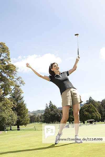 Caucasian woman cheering on golf course