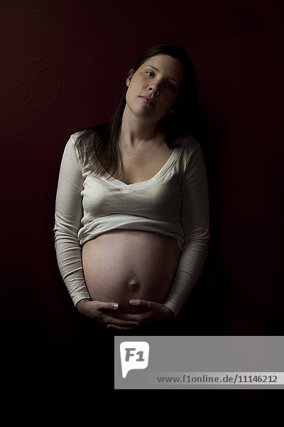 Serious pregnant woman holding her belly