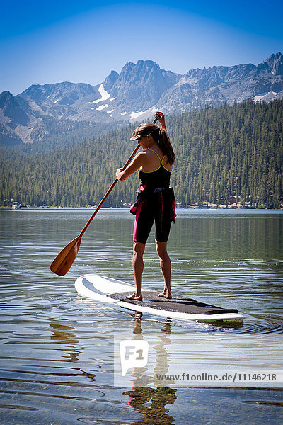 Mixed race woman on paddle board in Lake Tahoe California United States