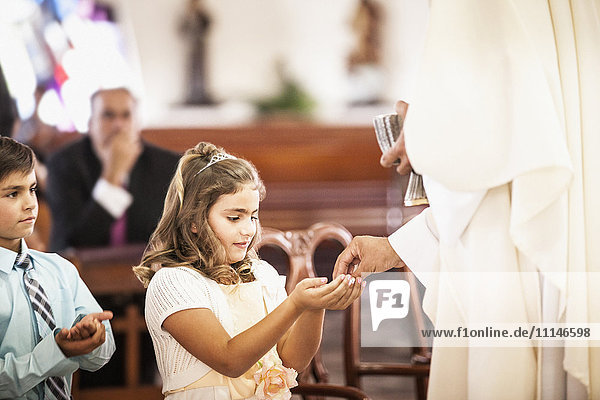 Mädchen bei ihrer Erstkommunion in der Kirche