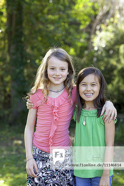 Smiling girls hugging in backyard