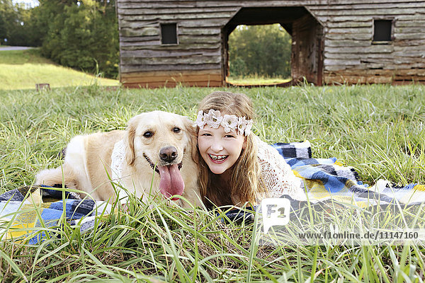 Caucasian girl laying on blanket with dog