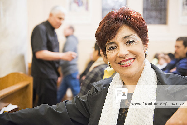 Hispanische Frau lächelt in der Kirche