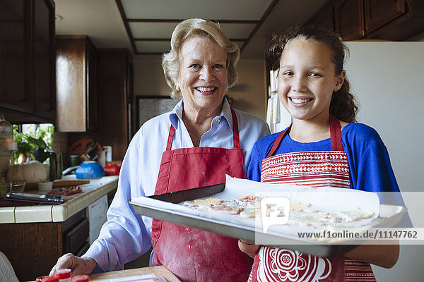 Großmutter und Enkelin backen Kekse in der Küche
