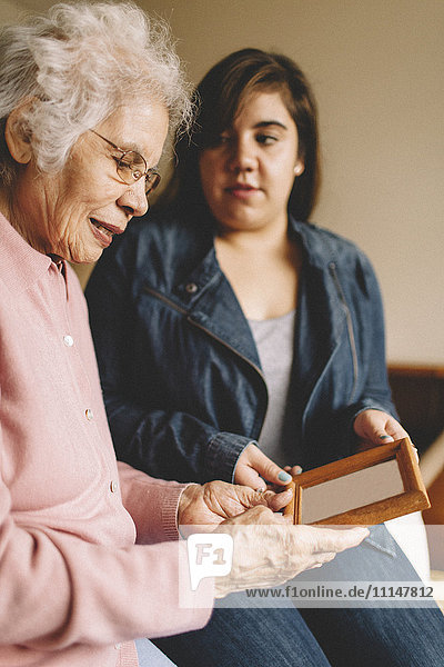 Grandmother and granddaughter admiring old photograph