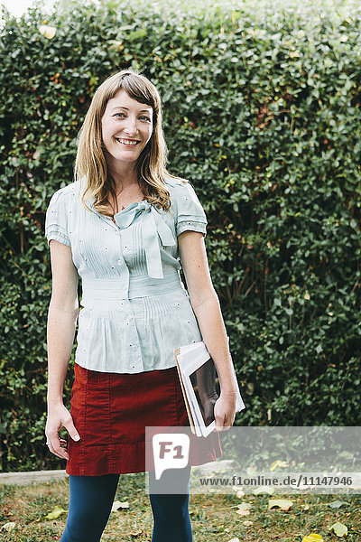 Mixed race businesswoman holding digital tablet in backyard