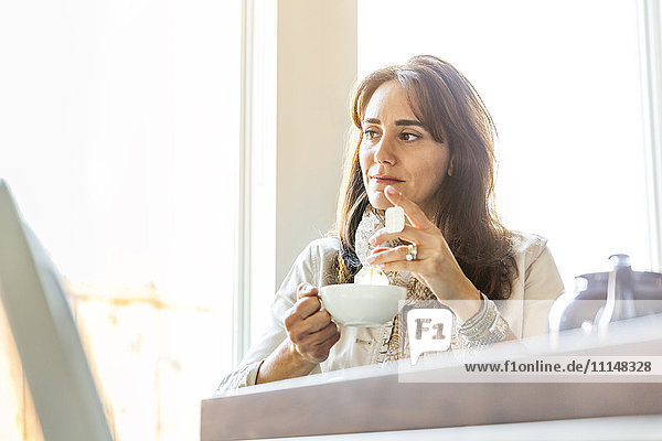 Caucasian woman drinking tea at table