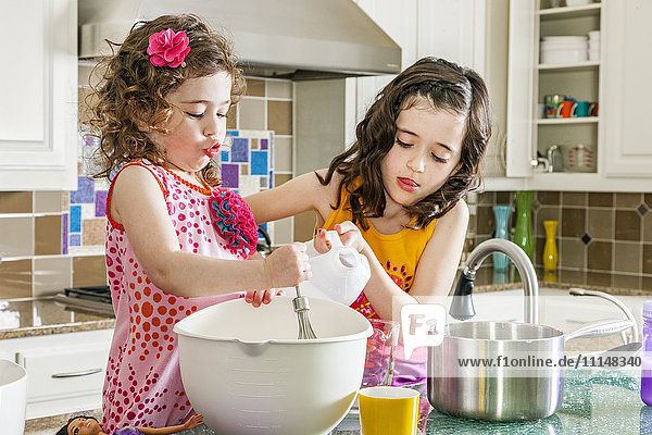 Sisters baking in kitchen