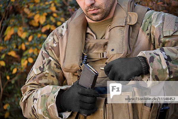 Soldat beim Laden einer automatischen Waffe während der Ausbildung