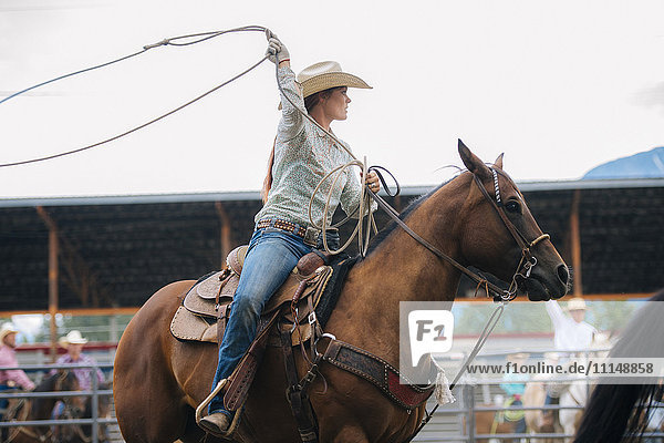 Kaukasisches Cowgirl wirbelt Lasso beim Rodeo