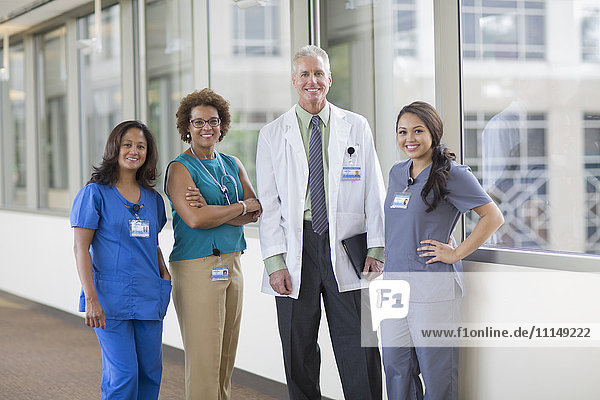 Arzt und Krankenschwestern lächelnd im Krankenhausflur