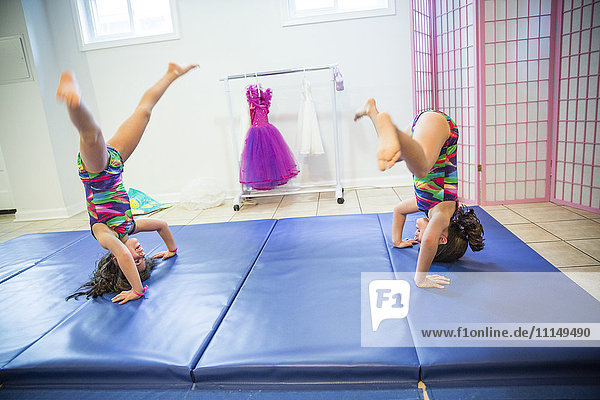 Twin sisters tumbling in gymnastics