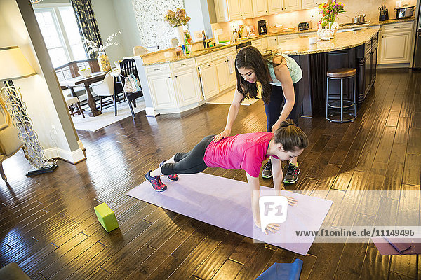 Frau trainiert mit Trainer zu Hause