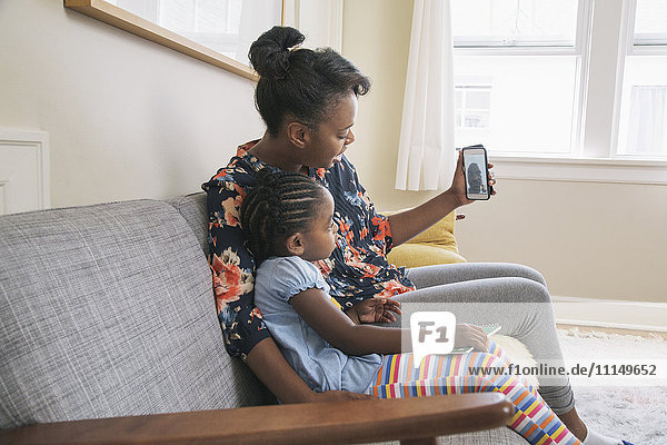 Afroamerikanische Mutter und Tochter beim Videochat mit dem Handy