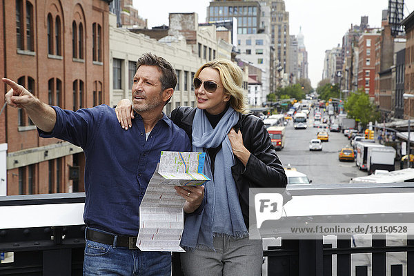 Kaukasisches Paar hält Karte in der Stadt  New York City  New York  Vereinigte Staaten