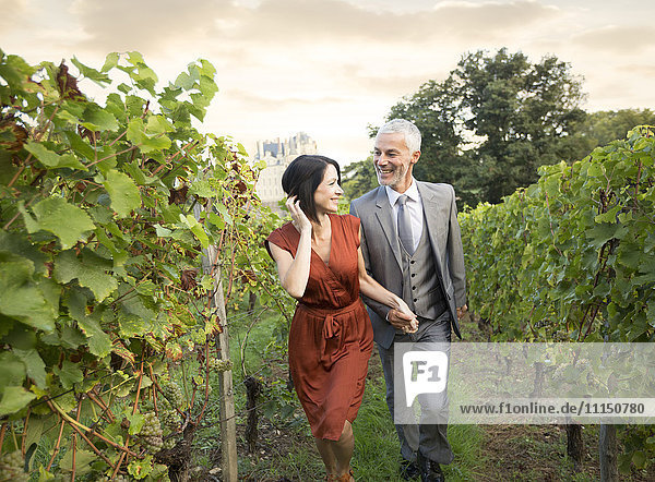 Kaukasisches Paar spaziert im Weinberg