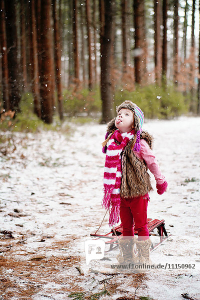 Caucasian girl catching snow on tongue