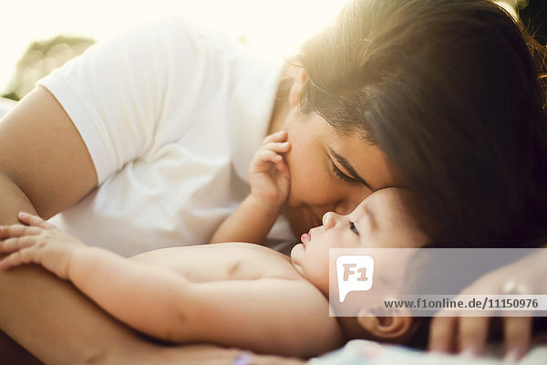 Gemischtrassige Mutter kuschelt mit Baby