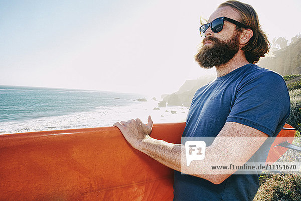 Caucasian man holding surfboard at beach