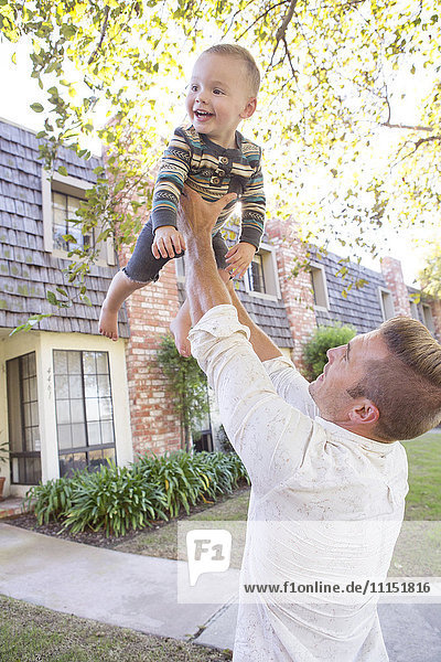 Caucasian man playing with son outdoors
