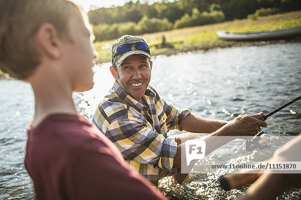 Kaukasischer Vater und Sohn beim Fischen im Fluss