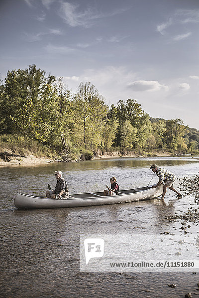 Drei Generationen kaukasischer Männer im Kanu auf dem Fluss