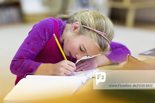 Kaukasisches Mädchen schreibt im Klassenzimmer