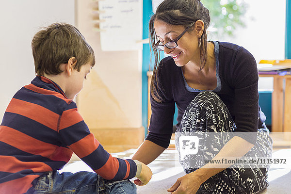 Montessori-Lehrerin hilft Schülerin im Klassenzimmer