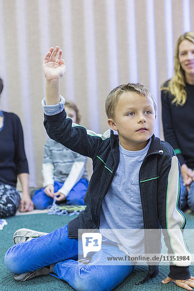 Junge hebt die Hand im Klassenzimmer