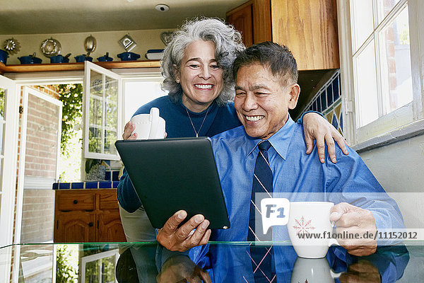 Ehepaar benutzt digitales Tablet in der Küche