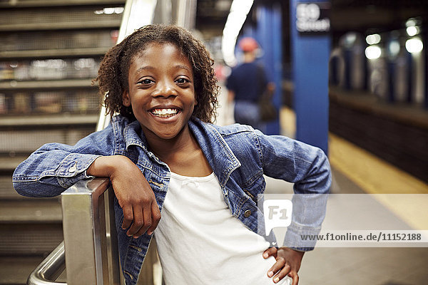 Smiling girl leaning on subway staircase