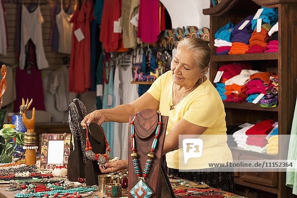 Lächelnde Frau  die in einem traditionellen Geschenkeladen arbeitet