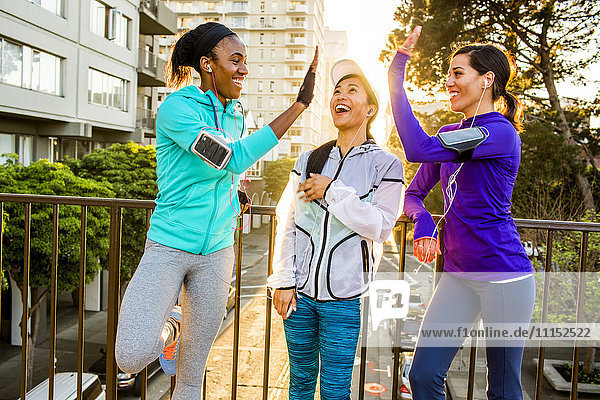 Runners high-fiving in city
