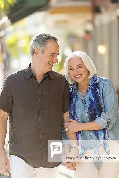 Older Caucasian couple holding hands outdoors