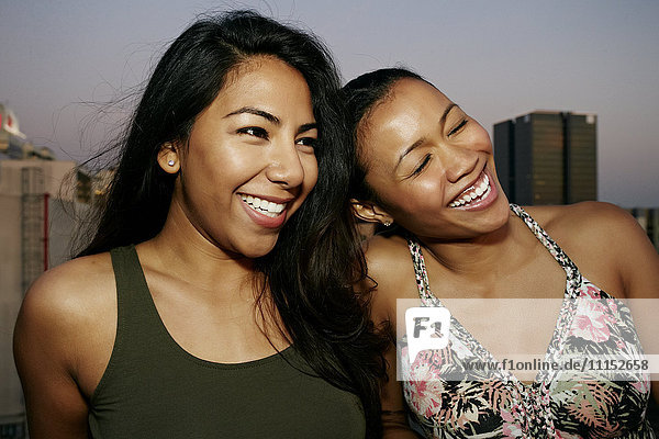 Women smiling on urban rooftop