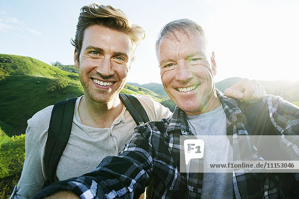 Kaukasischer Vater und Sohn machen ein Selfie auf einer ländlichen Hügelkuppe