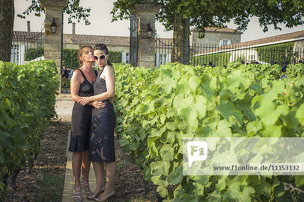 Kaukasisches lesbisches Paar umarmt sich im Weinberg