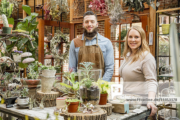 Caucasian employees smiling in plant nursery