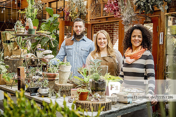 Employee and customers smiling in plant nursery