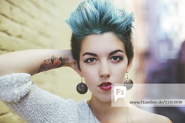Stylish Caucasian woman with earrings and dyed hair
