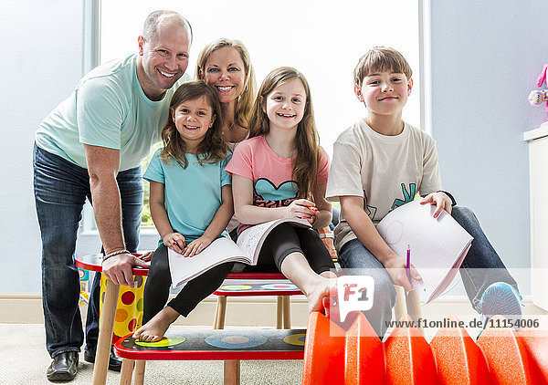 Caucasian family smiling at table in playroom