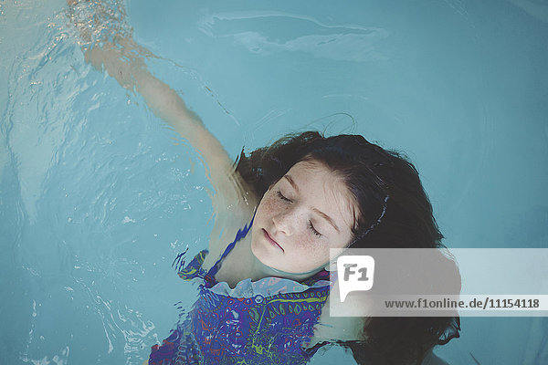 Kaukasisches Mädchen schwimmt im Schwimmbad