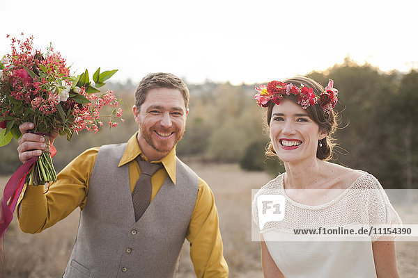 Braut und Bräutigam lächelnd in einem ländlichen Feld
