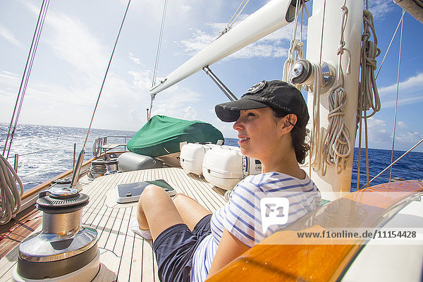 Caucasian woman relaxing on sailboat deck