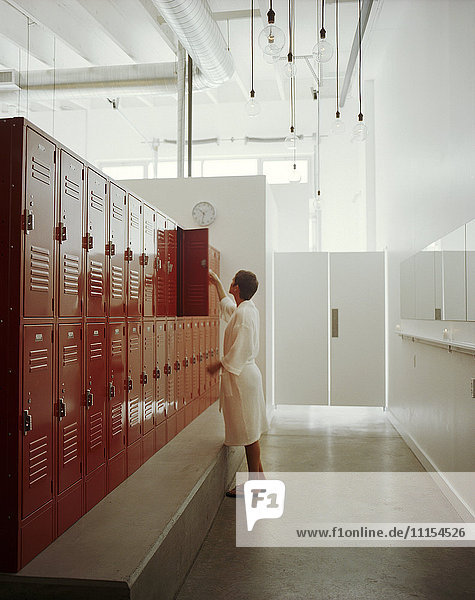 Woman opening locker in locker room