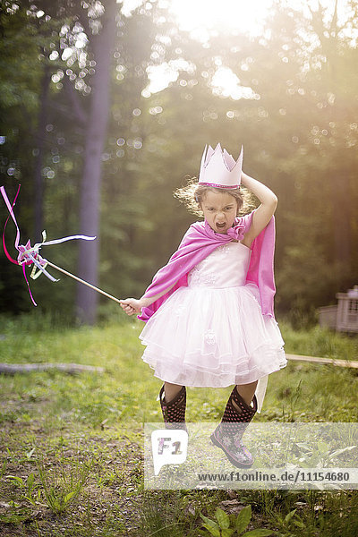 Girl playing princess in backyard