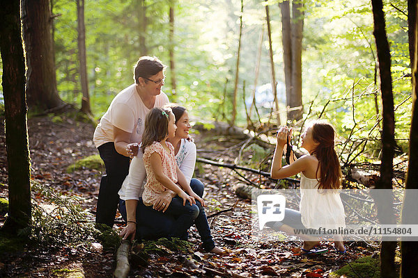 Kaukasisches Mädchen fotografiert Familie im Wald