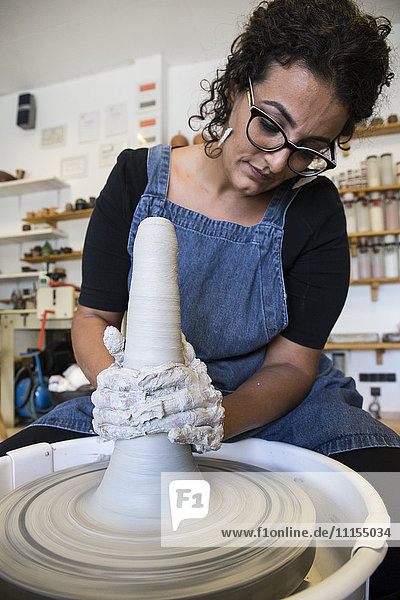 Frau bei der Arbeit mit der Töpferscheibe in einer Keramikwerkstatt