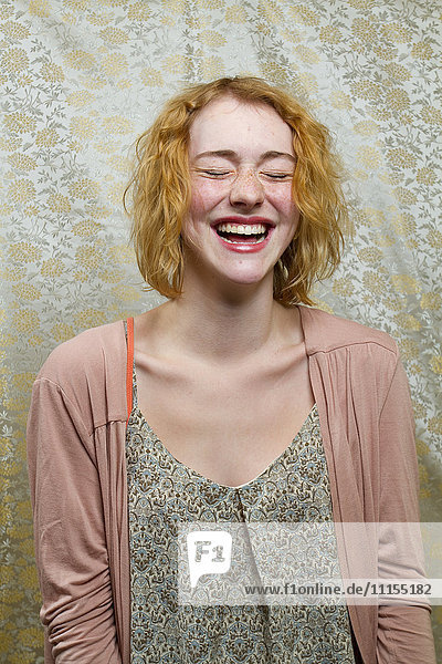 Caucasian woman laughing with eyes closed