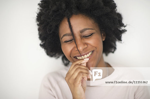 Lächelnde schwarze Frau spielt mit Haaren